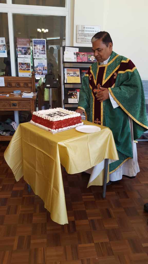 Fr. Jose, parish priest for St. Simon Stock Catholic Church, cutting his birthday cake.